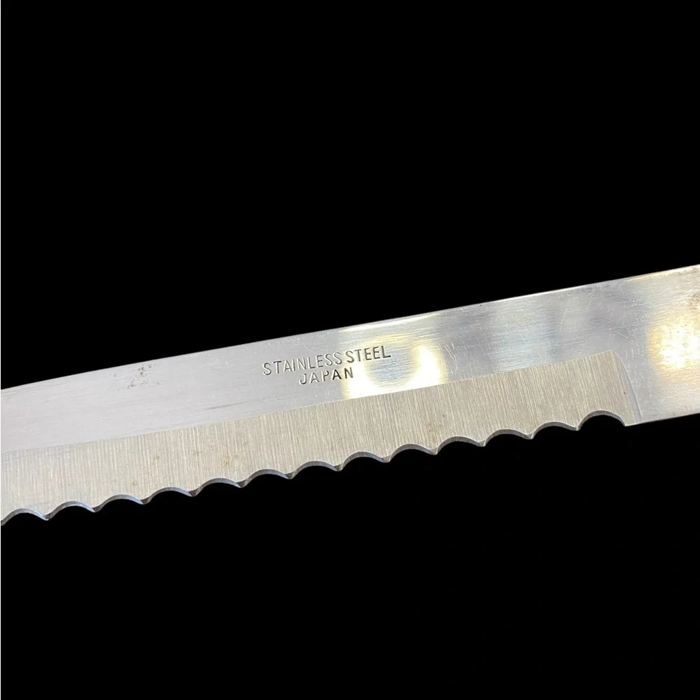 Vintage stainless steel serrated kitchen knife with a wooden handle. 9” long